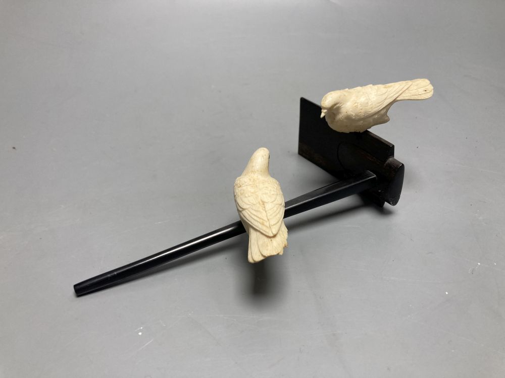 A Japanese ivory group of two carved doves, resting on a hardwood perch, length 21cm